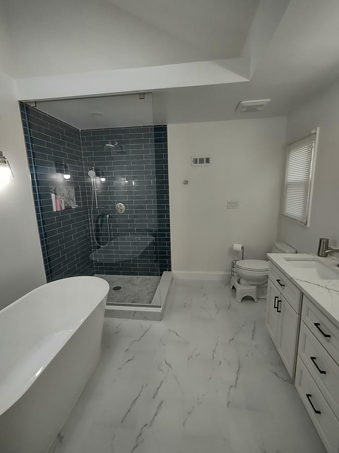 Teal tiled walk-in shower beside a dark vanity