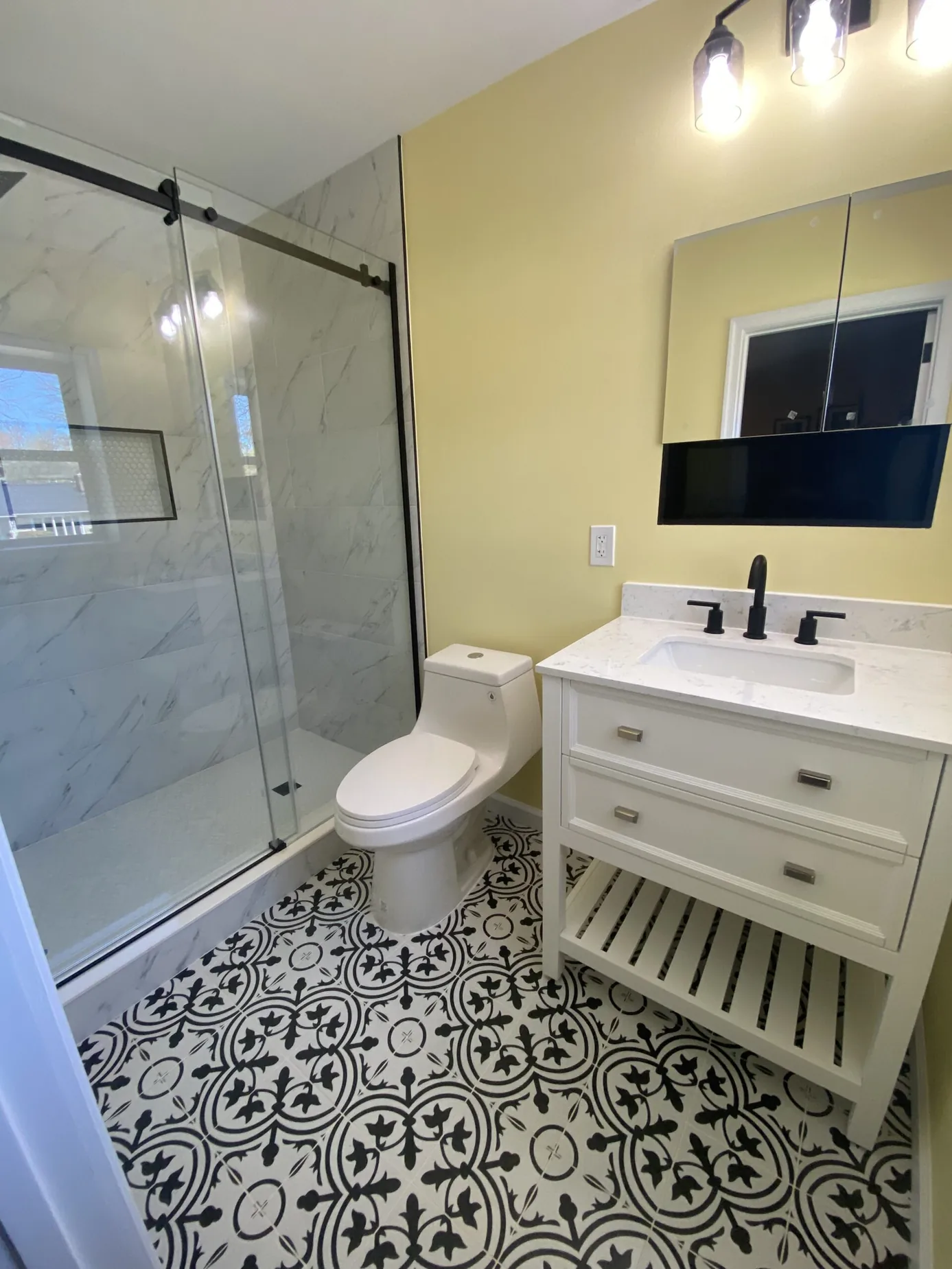 Teal tiled walk-in shower beside a dark vanity
