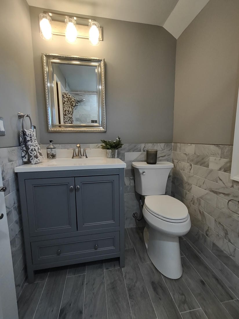 Teal tiled walk-in shower beside a dark vanity