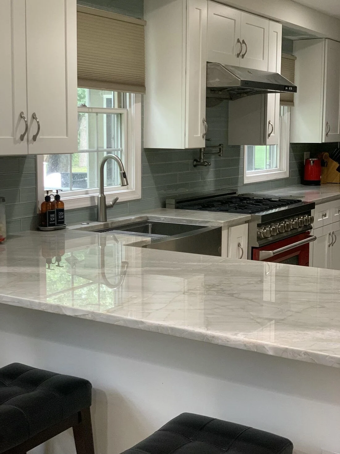 White kitchen remodel with an island and gray subway tile
