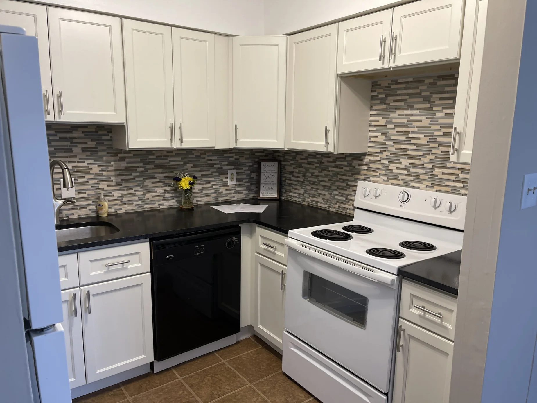 White kitchen remodel with an island and gray subway tile