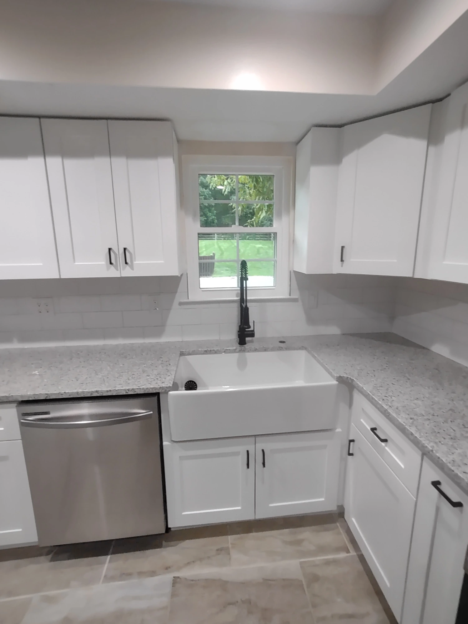 White kitchen remodel with an island and gray subway tile